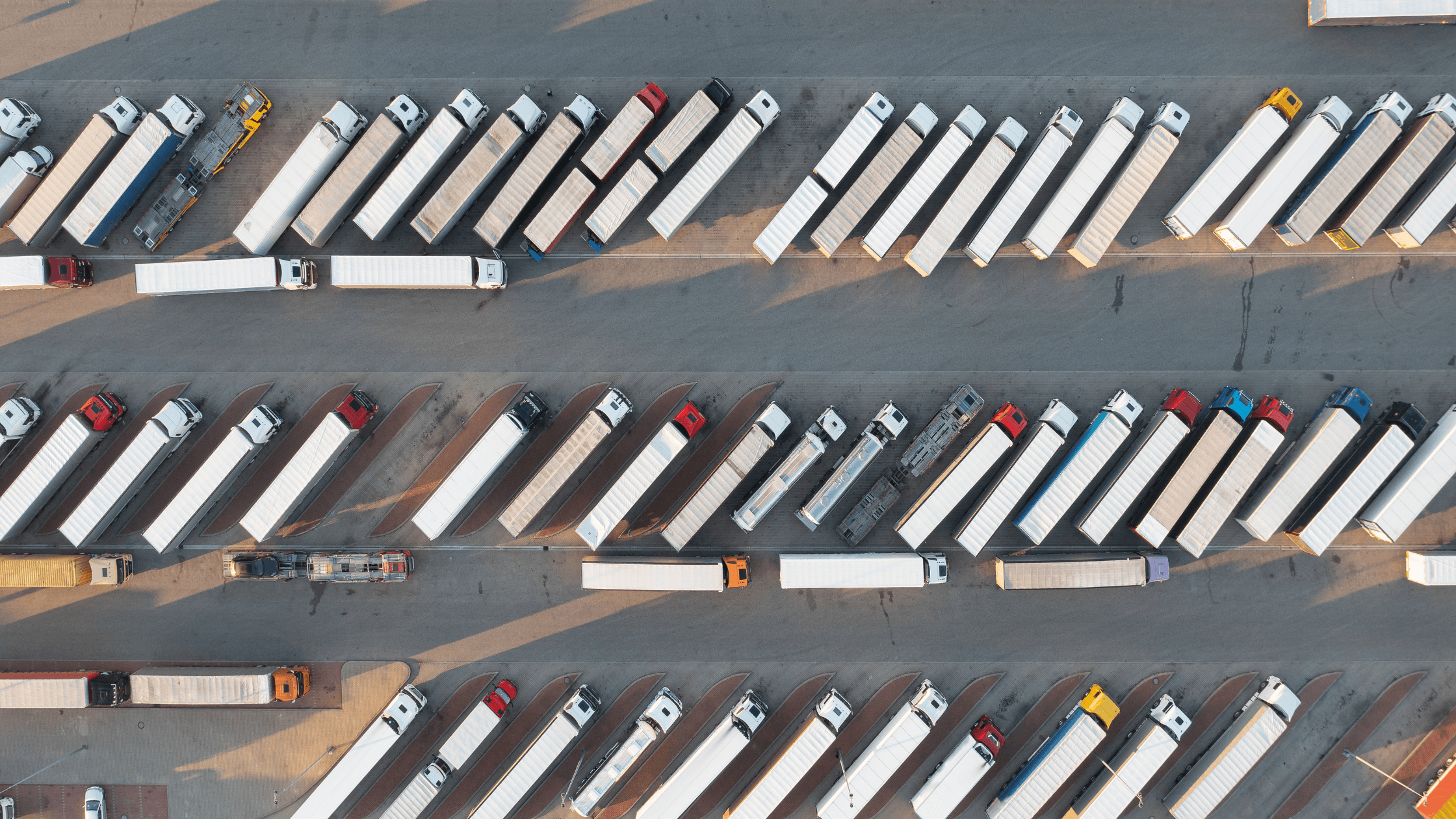 Aerial view of a secure, well-lit truck parking facility at Exit 312 in Calhoun, Georgia, surrounded by parked semi-trucks and highway access.
